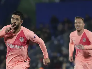 Striker Barcelona, Luis Suarez, melakukan selebrasi usai mencetak gol ke gawang Getafe pada laga La Liga di Stadion Alfonso Perez, Minggu (6/1). Barcelona menang 2-1 atas Getafe. (AP/Manu Fernandez)