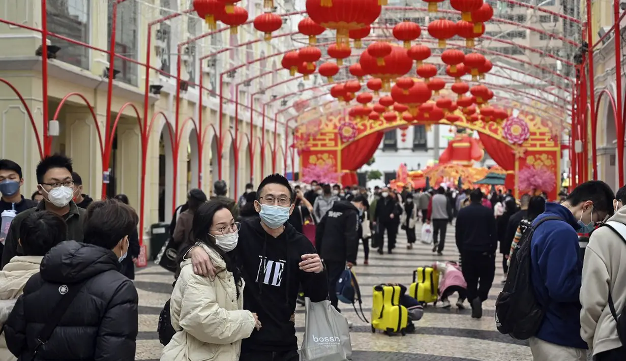 Pelancong asal China berjalan-jalan di daerah kantong China, Makau, 17 Januari 2023. Ledakan pariwisata China yang diharapkan selama liburan Tahun Baru Imlek minggu depan tampaknya akan lebih cepat terjadi. (Peter PARKS/AFP)