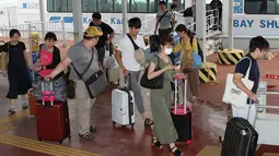 Penumpang yang terdampar semalam di Bandara Internasional Kansai tiba dengan kapal di pelabuhan Kobe, Rabu (5/9). Topan jebi membuat beberapa bagian di landasan pacu serta lantai basement bandara Kansai di Osaka, Jepang terendam banjir. (AFP/JIJI PRESS)