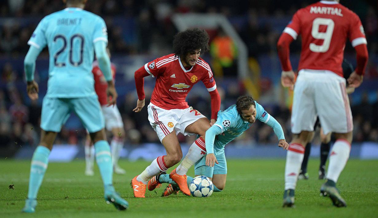 Pemain Manchester United, Marouane Fellaini berebut bola dengan pemain PSV Eindhoven, Andres Guardado pada lanjutan liga Champions grup B di Stadion Old Trafford, Manchester, Kamis (26/11/2015) dini hari WIB. (AFP Photo/Oli Scarff)