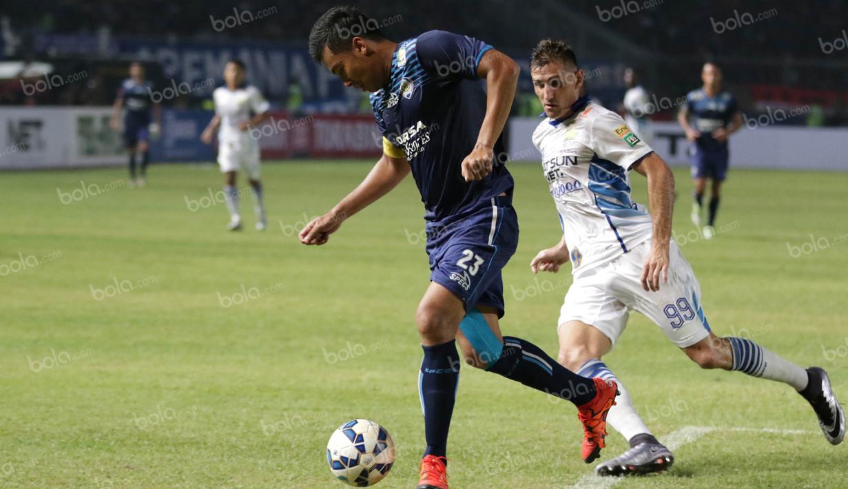 Bek Arema Cronus, Hamka Hamzah, berusaha melewati striker Persib Bandung, Juan Belencoso, pada babak final Torabika Bhayangkara Cup 2016 di SUGBK, Jakarta, Minggu (3/4/2016). Arema Cronus menang 2-0 atas Persib. (Bola.com/Nicklas Hanoatubun)