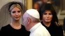 Paus Fransiskus berjalan melewati Ivanka dan Ibu Negara AS, Melania Trump pada pertemuan pribadi bersama Presiden Donald Trump di Vatikan, (24/5). Melania dan Ivanka mengenakan penutup kepala hitam saat menemui Paus. (AP Photo/Alessandra Tarantino, Pool)
