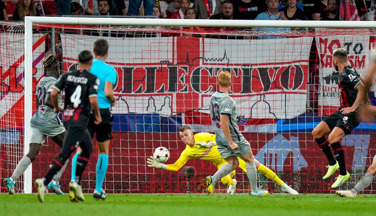 Penjaga gawang RB Salzburg Philipp Koehn gagal menghalau bola tendangan pemain AC Milan Alexis Saelemaekers pada pertandingan sepak bola Grup E Liga Champions di Stadion Salzburg, Salzburg, Austria, 6 September 2022. Pertandingan berakhir imbang 1-1. (AP Photo/Florian Schrotter)