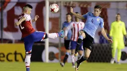 Gelandang Uruguay, Federico Valverde, berebut bola dengan bek Paraguay, Jorge Moreira, pada laga kualifikasi piala dunia 2018 di Stadion Defensores del Chaco, Rabu (6/9/2017). Uruguay menang 2-1 atas Paraguay. (AP/Jorge Saenz)