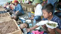 Anak petani Telukjambe melakukan aksi kubur diri di halaman Monas, Jakarta, Senin (1/5). Aksi kubur diri dilakukan untuk mendapat perhatian pemerintah terkait konflik agraria di Telukjambe, Karawang. (Liputan6.com/Yoppy Renato)