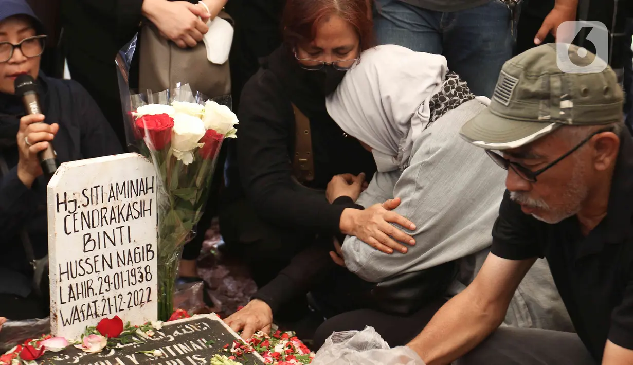 Tangis keluarga dan kerabat saat prosesi pemakaman aktris senior Aminah Cendrakasih atau Mak Nyak di Taman Pemakaman Umum Karet Bivak, Jakarta, Kamis (22/12/2022). Pemeran Mak Nyak dalam Si Doel Anak Sekolahan meninggal dunia pada 21 Desember 2022 pukul 19.40 WIB karena mengidap penyakit glaukoma yang sudah menahun. (Liputan6.com/Herman Zakharia)