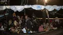 Pengungsi Rohingya duduk di perahu saat tiba di Pelabuhan Krueng Geukueh di Aceh Utara, Jumat pagi (31/12/2021). Para pengungsi yang mayoritas perempuan dan anak-anak tersebut dalam kondisi lemas dan kedinginan, karena diguyur hujan. (AP Photo/Zik Maulana)