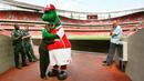 Maskot dinosaurus tersebut sudah setia menemani Arsenal sejak tahun 1993 silam. Bahkan sejak Arsene Wenger belum menjadi juru taktik di Meriam London tersebut. (AFP/Adrian Dennis)