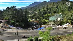 Pengendara motor melintasi kawasan longsor di Desa Ciloto, Kabupaten Cianjur, Jawa Barat, Kamis (29/3). Longsor di bahu Jalan Raya Puncak itu membuat arus lalu lintas ditutup sementara bagi pengendara roda empat. (Merdeka.com/Arie Basuki)