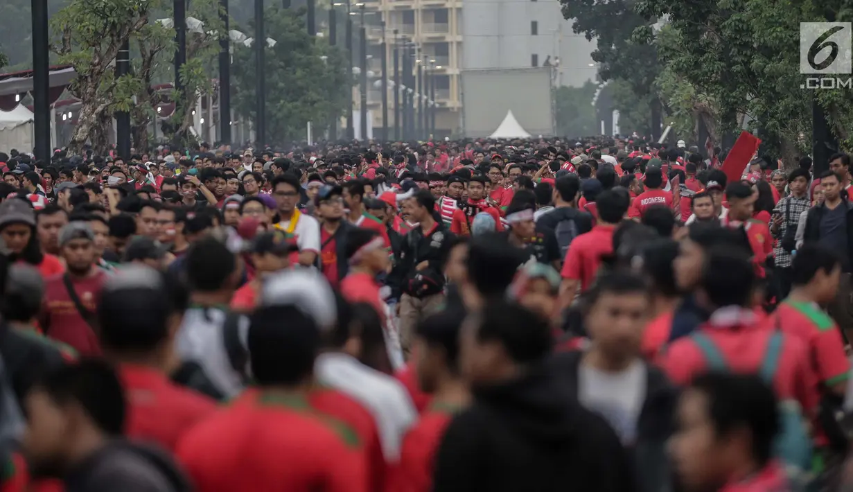 Ribuan suporter Timnas Indonesia beratribu merah putih mulai berdatangan di Stadion Gelora Bung Karno (GBK), Senayan, Jakarta, Minggu (14/1). Presiden Jokowi dijadwalkan bakal ikut menyaksikan pertandingan ini. (Liputan6/Faizal Fanani)