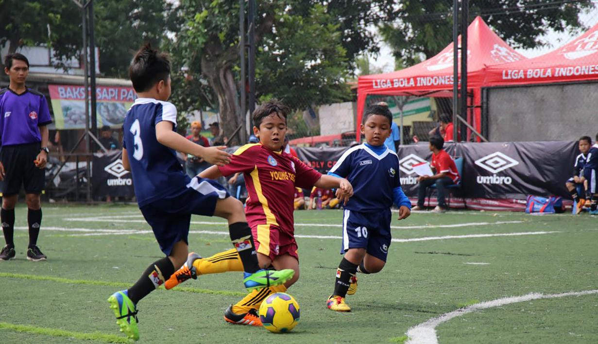 Seorang anak berusaha melewati lawannya saat berlaga pada Liga Bola Indonesia. Persaingan tidak kalah sengit untuk kategori U-9, sebanyak 12 tim yang bertarung dalam kategori ini. (Bola.com/Vitalis Yogi Trisna)