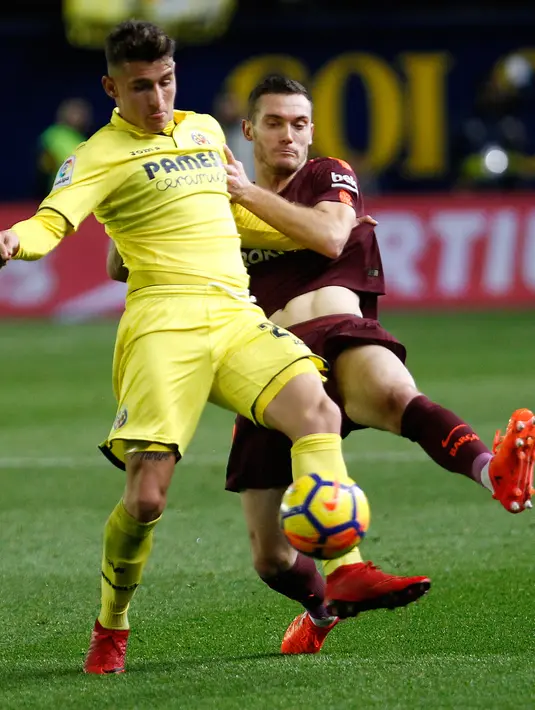 Pemain Villarreal, Raba berebut bola dengan pemain Barcelona, Thomas Vermaelen pada jornada ke-15 La Liga di Stadion Ceramica, Minggu (10/12). Barca menyudahi pertandingan ini dengan kemenangan 2-0 atas Villarreal.  (AP/Alberto Saiz)