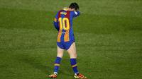 Striker Barcelona, Lionel Messi, tertunduk lesu usai ditaklukkan Real Madrid pada laga Liga Spanyol di Stadion Alfredo di Stefano, Minggu (11/4/2021). Real Madrid menang dengan skor 2-1. (AP/Manu Fernandez)