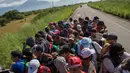 Rombongan imigran Amerika Tengah tujuan Amerika Serikat menumpang truk saat melintasi perbatasan Tapanatepec dengan Niltepec di Meksiko, Senin (29/10). (AP Photo/Rodrigo Abd)