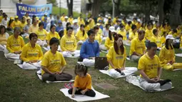 Sekelompok orang melakukan meditasi Falun Gong sebelum demonstrasi menentang pemerintah China, di luar Balaikota Los Angeles, California, Kamis (15/10). Presiden China Xi Jinping akan melakukan kunjungan kenegaraan di Washington. (REUTERS/Lucy Nicholson)