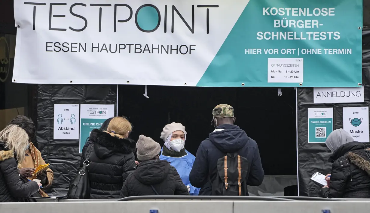 Orang-orang menunggu untuk melakukan tes covid-19 di pusat kota Essen, Jerman, Rabu (12/1/2022). Jerman melaporkan lebih dari 80.000 kasus virus corona dalam sehari yang merupakan tertinggi sejak pandemi pada Rabu. (AP Photo/Martin Meissner)