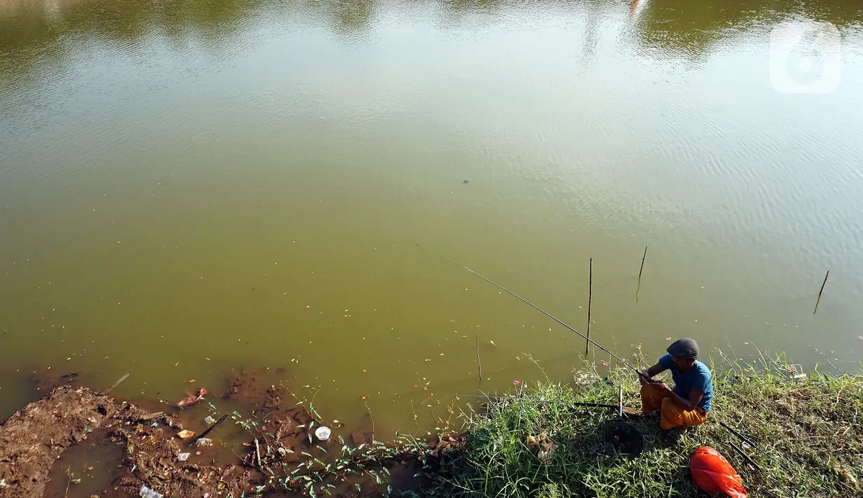Seorang pria memancing di Waduk Cavalio, Jakarta, Jumat (4/10/2019). Dinas Sumber Daya Air DKI Jakarta mengalokasikan anggaran sebesar Rp 288,49 miliar pada 2020 untuk program naturalisasi sungai dan waduk guna mengatasi masalah banjir di Ibu Kota. (Liputan6.com/Johan Tallo)