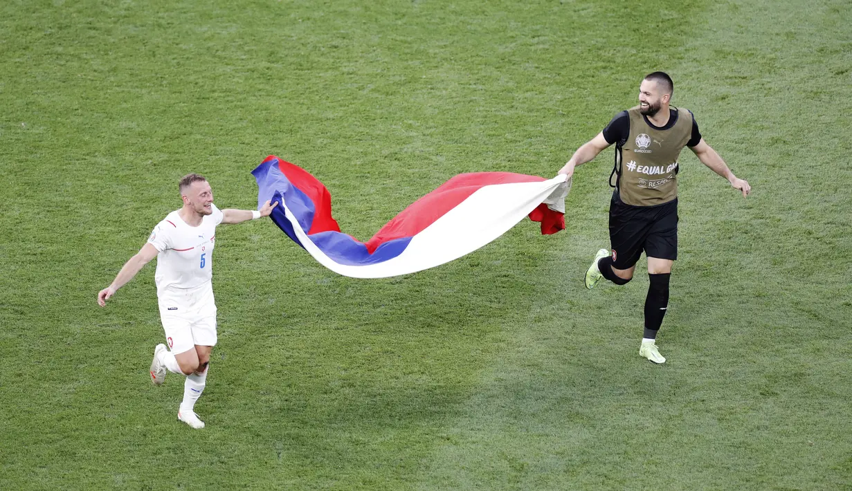 Pemain Republik Ceska, Vladimir Coufal, bersama rekannya membawa bendera negaranya saat merayakan kemenangan atas Belanda pada babak 16 besar Euro 2020 di Puskas Arena, Minggu (27/7/2021). (AP Photo/Laszlo Balogh, Pool)