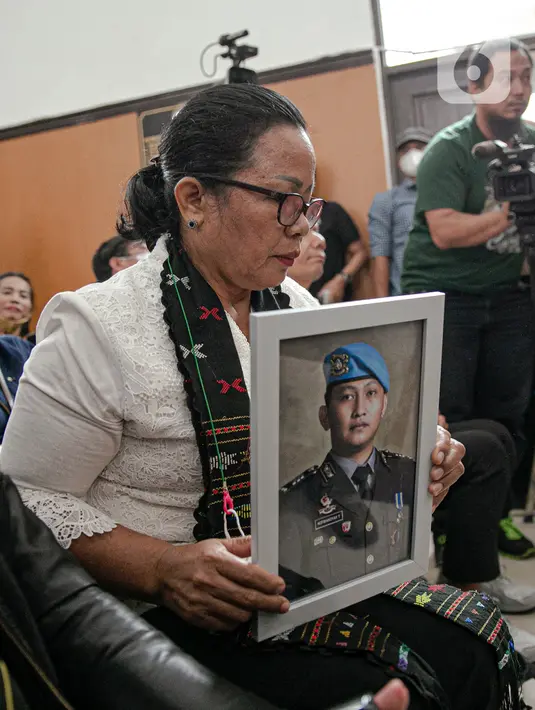 Ibunda Nofriansyah Yosua Hutabarat atau Brigadir J, Rosti Simanjuntak membawa foto sang anak saat menghadiri sidang vonis terdakwa Ferdy Sambo di Pengadilan Negeri Jakarta Selatan, Senin (13/2/2023). Rosti didampingi kuasa hukum keluarga Martin Lukas Simanjuntak menonton langsung sidang putusan terhadap Ferdy Sambo. (Liputan6.com/Faizal Fanani)