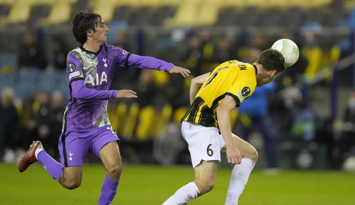 Bek Vitesse Arnhem, Jacob Rasmussen mengoper bola di sebelah penyerang Tottenham Hotspur, Bryan Gil pada matchday ketiga Grup G Europa Conference League 2021/2022 di Stadion Gelredome, Kamis (21/10/2021) malam WIB. Tottenham menelan kekalahan 0-1 di markas Vitesse Arnhem. (AP Photo/Peter Dejong)