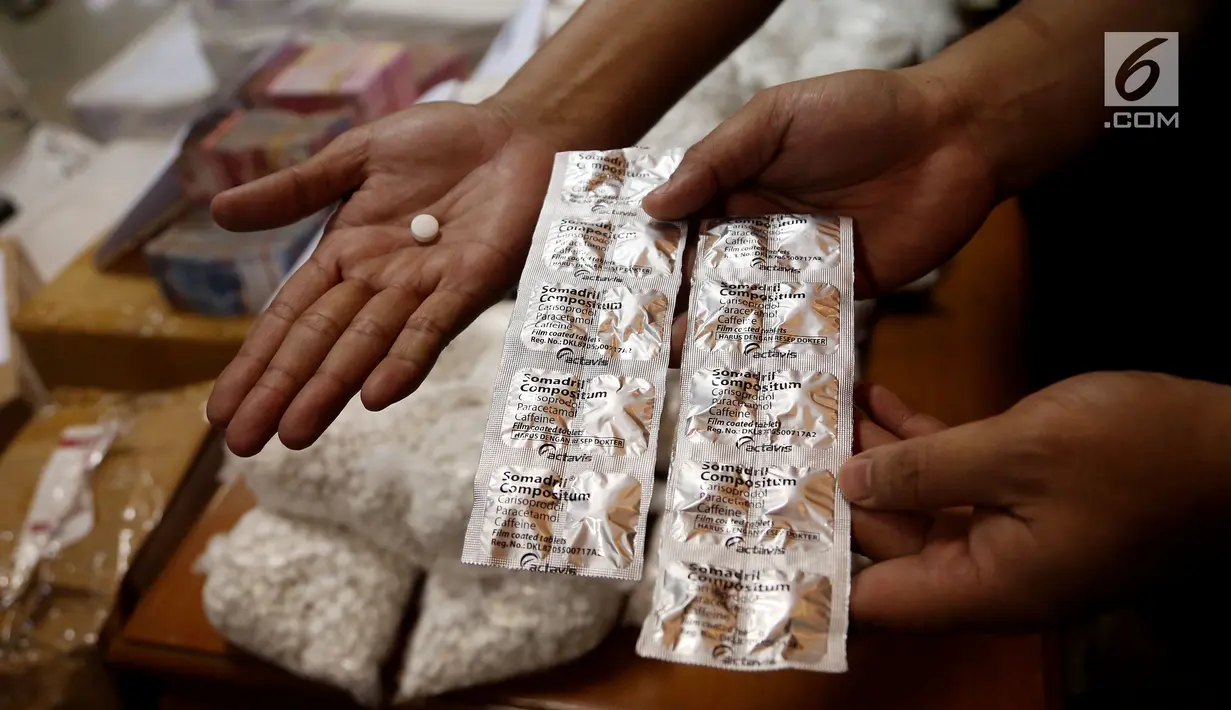 Petugas menunjukan kemasan obat PCC di Bareskrim Polri, Jakarta, Jumat (22/9). Selain itu diamankan pula uang tunai Rp 450 juta yang digunakan sebagai suap. (Liputan6.com/JohanTallo)