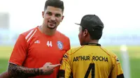 Bek asing Arema FC, Arthur Cunha, berfoto dengan ofisial Mitra Kukar yang mengenakan jersey-nya. (Bola.com/Iwan Setiawan)