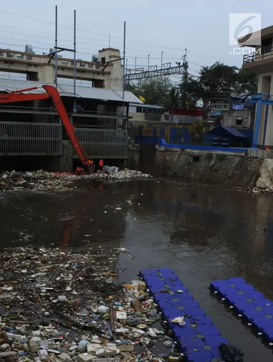 Petugas membersihkan sampah yang terbawa arus sungai Ciliwung, di Jakarta, Selasa (23/10). Dinas Lingkungan Hidup mengantisipasi terjadinya peningkatan volume sampah saat musim penghujan tiba di setiap pintu air Jakarta. (Merdeka.com/Imam Buhori)