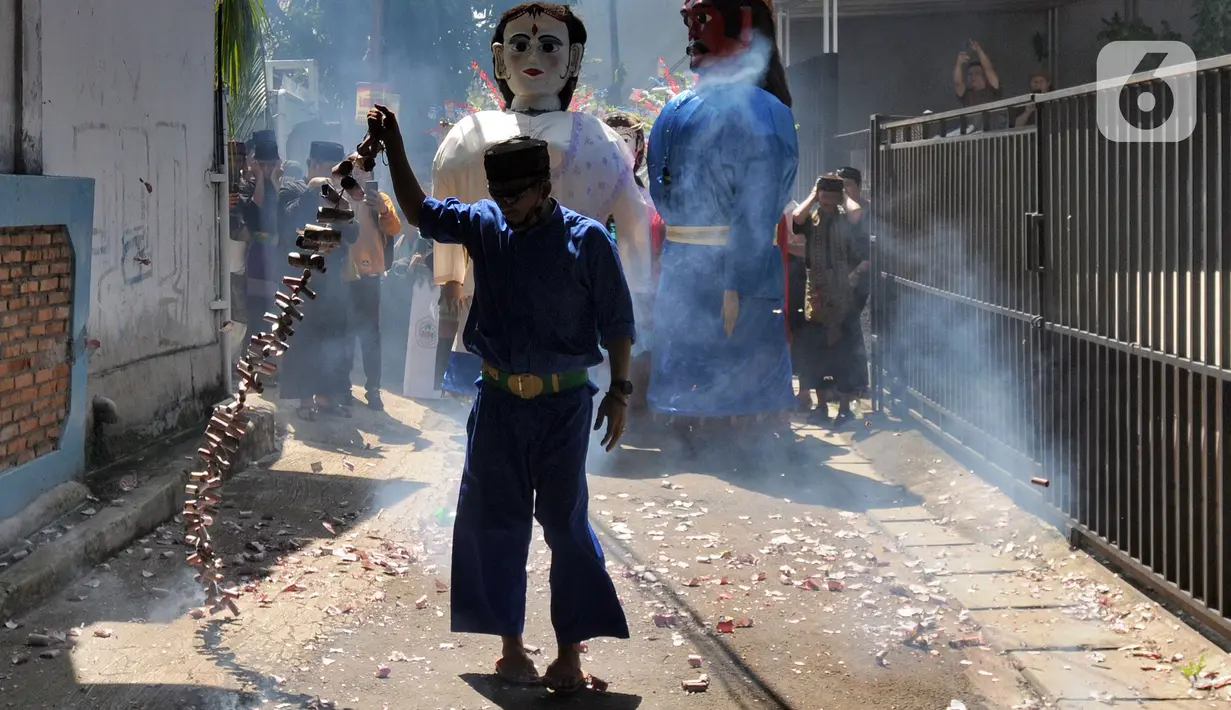 Warga memegang petasan besar yang dibakar saat kegiatan pawai jelang Ramadan di kawasan Pondok Cabe Ilir, Tangerang Selatan, Banten, Minggu (27/3/2022). Kegiatan ini dalam rangka mengajak kaum muslim untuk melakukan ibadah puasa satu bulan penuh saat Ramadan. (merdeka.com/Arie Basuki)