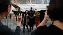 Peniru superhero, Matthias Balke berfoto bersama wisatawan dengan kostum Batmannya di Hollywood Boulevard, Los Angeles, 2 Maret 2017. Mereka memberikan gambaran ironis seniman jalanan yang hidup dari hasil uang masyarakat lokal Hollywood. (AP/Jae C. Hong)