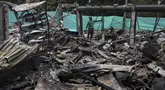 Seorang pekerja berdiri di sisa-sisa gudang suku cadang setelah bom mobil yang mematikan meledak di belakang kantor polisi di Timba, Cauca, Kolombia, Rabu, 20 September 2023. (AP Photo/Andres Quintero)