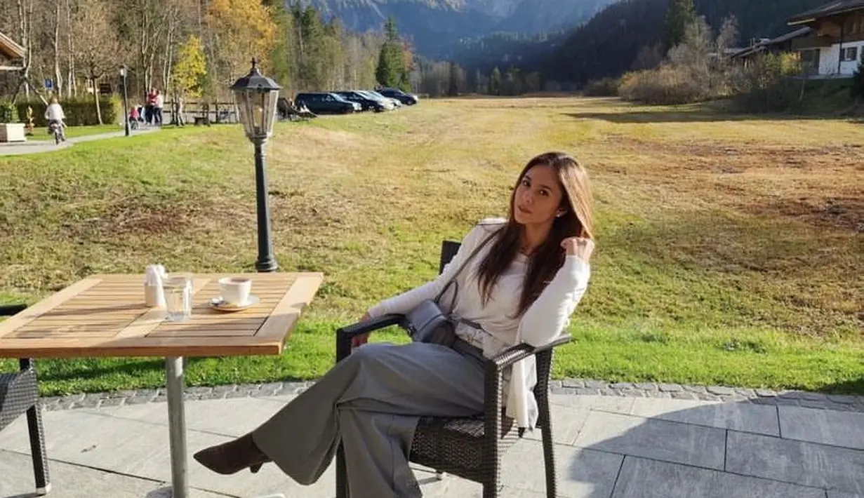 Seperti potret ini, berpose dengan latar belakang taman dan pegunungan Swiss yang Indah, Wulan Guritno tampil stylish dengan white long sleeve top, dengan grey loose pants dan suede shoes. @wulanguritno.
