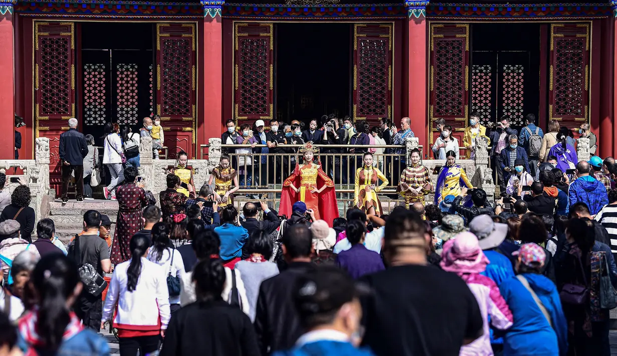Orang-orang mengambil gambar saat model menampilkan cheongsam, juga dikenal sebagai qipao, selama Festival Budaya Cheongsam Shenyang di Istana Kekaisaran Shenyang di Shenyang, provinsi Liaoning, Chiina, Rabu (23/9/2020). (Photo by STR / AFP)