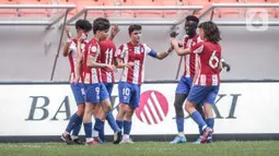 Pemain Atletico Madrid U-18 merayakan gol yang dicetak rekan setimnya ke gawang Bali United U-18 pada laga perdana International Youth Championship (IYC) 2021 di Jakarta International Stadium (JIS), Jakarta, Rabu (13/4/2022). Atletico Madrid U-18 menang dengan skor 5-0. (Liputan6.com/Faizal Fanani)