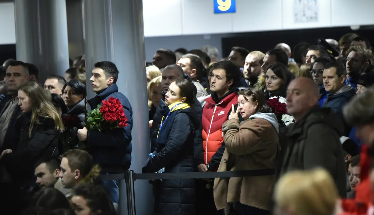 Keluarga korban menghadiri upacara penghormatan 11 warga Ukraina yang tewas dalam insiden jatuhnya pesawat Ukraine International Airlines di Iran (8/1) lalu, Bandara Boryspil Kiev, Ukraina, Minggu (19/1/2020). Pesawat tersebut jatuh oleh rudal pasukan IRGC. (Sergei SUPINSKY / AFP)