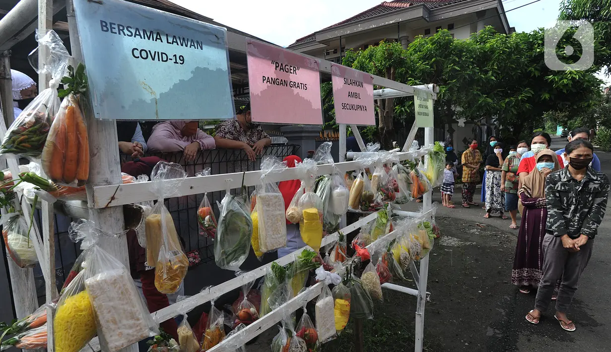 Warga terdampak Covid-19 antre mengambil bahan pangan gratis di Kompleks Bumi Menteng Asri, Rt 01/18, Kelurahan Menteng, Bogor, Kamis (21/5/2020).  Bahan pangan tersebut disediakan secara swadaya warga setempat dan sudah berjalan selama Bulan Ramadan. (merdeka.com/Arie Basuki)