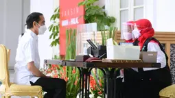 Presiden Joko Widodo atau Jokowi menjalani pendaftaran dan verifikasi data saat mengikuti vaksinasi COVID-19 di Istana Merdeka, Jakarta, Rabu (13/1/2021). Vaksinasi ini jadi titik awal vaksinasi nasional sebagai upaya penanganan pandemi COVID-19. (Biro Pers Sekretariat Presiden/Muchlis Jr)