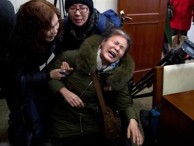 Ibu dari korban pasawat Malaysia Airlines MH370, Wang Yulian menangis histeris sebelum bertemu dengan pejabat maskapai tersebut di Beijing, China (18/1). Mereka meluapkan kesedihan dan kekecewaannya. (AP Photo/Ng Han Guan)