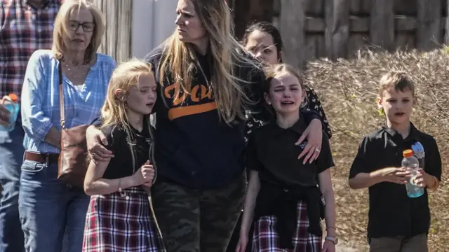 Para murid dan wanita menuju tempat pertemuan dengan orang tua di Woodmont Baptist Church setelah penembakan, pembantaian di The Covenant School, Nashville, Amerika Serikat pada 27 Maret 2023. (AP/John Bazemore)