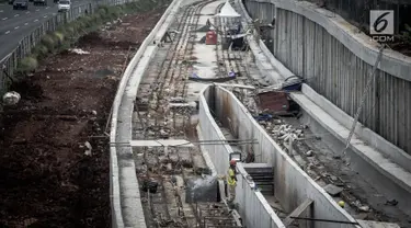 Pekerja berada di proyek Light Rail Transit (LRT) di sisi jalan Tol Jagorawi, Cibubur, Jakarta, Jumat (2/6). Pembangunan LRT Jabodebek koridor Cawang-Cibubur sudah mencapai 25 persen dan ditarget rampung pada 2019. (Liputan6.com/Faizal Fanani)