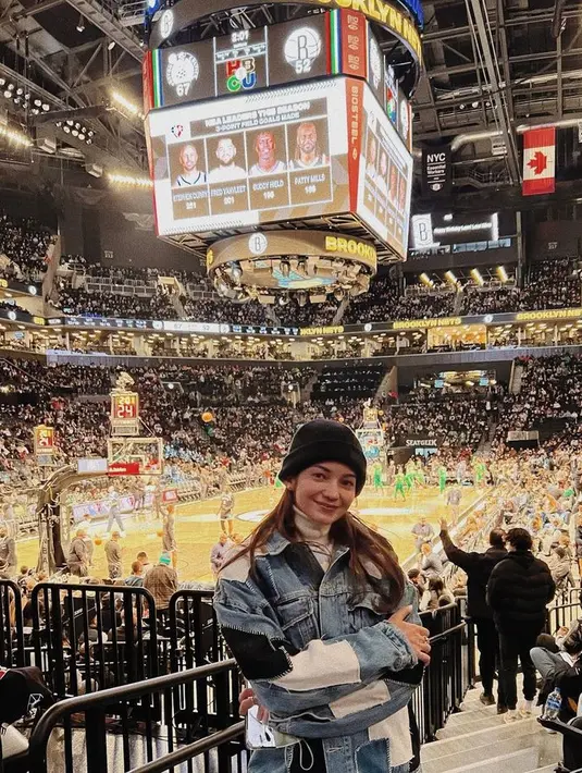 Beannie hat dan denim jacket plus halter jadi gaya andalan Enzy saat nonton NBA. [Foto: Instagram @enzystoria]