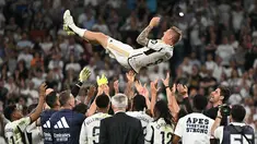Gelandang Real Madrid #08 Toni Kroos terlempar ke udara oleh rekan satu timnya saat melawan Real Betis pada pekan ke-38 (pekan terakhir) La Liga 2023/2024 di Santiago Bernabeu, Minggu (26/5/2024). (JAVIER SORIANO / AFP)