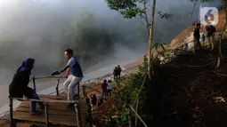 Pengunjung menunggu hilangnya kabut yang menutupi kawasan Gunung Luhur di Desa Citorek Kidul, Kecamatan Cibeber, Kabupaten Lebak, Banten, Sabtu (23/11/2019). Wisata “Negeri Di Atas Awan” yang sempat tutup sementara sejak September 2019 lalu ini kembali ramai oleh wisawatan. (merdeka.com/Arie Basuki)