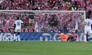 Penyerang Atletico Madrid Kanada #15, Jonathan David (kanan), mencetak gol kedua timnya melewati kiper Real Madrid Belgia #01, Thibaut Courtois, selama pertandingan liga Spanyol antara Club Atletico de Madrid dan Real Madrid CF di stadion Metropolitano di Madrid pada 20 September 2026. (Thomas COEX/AFP)
