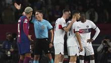 Wasit Istvan Kovacs mempersilahkan pemain Barcelona, Ronald Araujo keluar lapangan setelah memberikan kartu merah saat melawan Paris Saint-Germain pada duel leg kedua perempat final Liga Champions 2023/2024 Stadion Olimpic Lluis Companys, Rabu (17/4/2024). Barca tersingkir dari Liga Champions karena kalah agregat 4-6. (AP Photo/Emilio Morenatti)