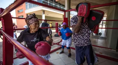 Gladys Ngwenya (kiri) dan Constance Ngubane (tengah) 79 tahun mengikuti latihan "Boxing Gogos" yang diselenggarakan oleh "A Team Gym" di Cosmo City di Johannesburg (19/9). Peserta "Boxing Gogos" berusia lebih dari 70 tahun. (AFP Photo/Gulshan Khan)