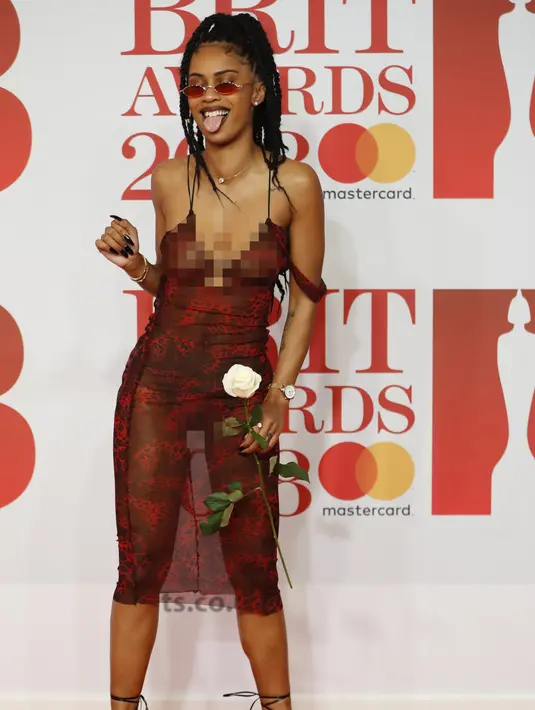 Gaya Diana De Brito, yang dikenal sebagai IAMDDB berpose di karpet merah saat tiba menghadiri BRIT Awards 2018 di London, Inggris (21/2). (AFP Photo/Tolga Akmen)