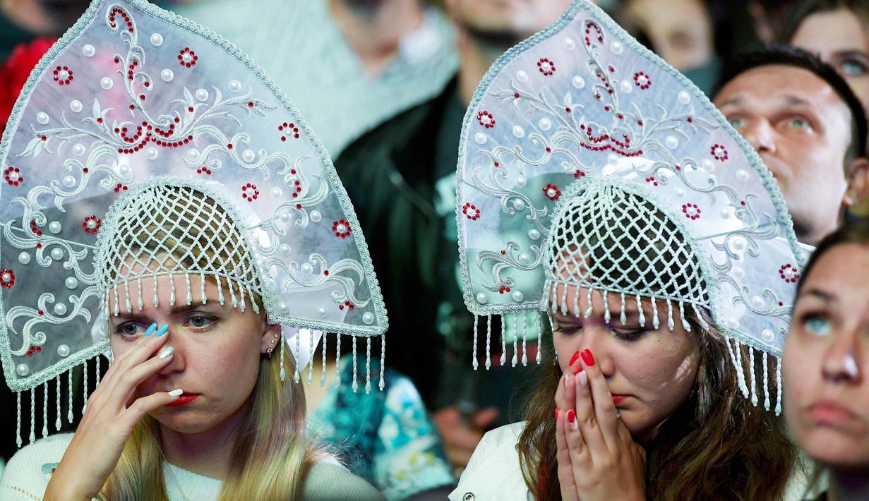 Dua orang suporter tampak kecewa usai Rusia kalah dari Kroasia pada laga perempat final Piala Dunia di Stadion Olimpiade Fisht, Sabtu (7/7/2018). Rusia kalah adu penalti dengan skor 3-4 dari Kroasia. (AFP/Olga Maltseva)