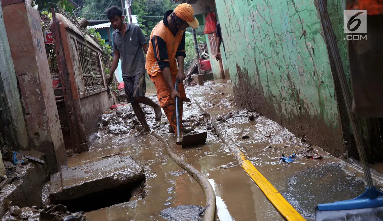 Petugas PPSU bersama warga membersihkan lumpur sisa banjir yang melanda kawasan Rawajati, Jakarta, Sabtu (27/4). Banjir akibat luapan air sungai Ciliwung sempat melanda kawasan ini pada Jumat (26/4). (Liputan6.com/Helmi Fithriansyah)