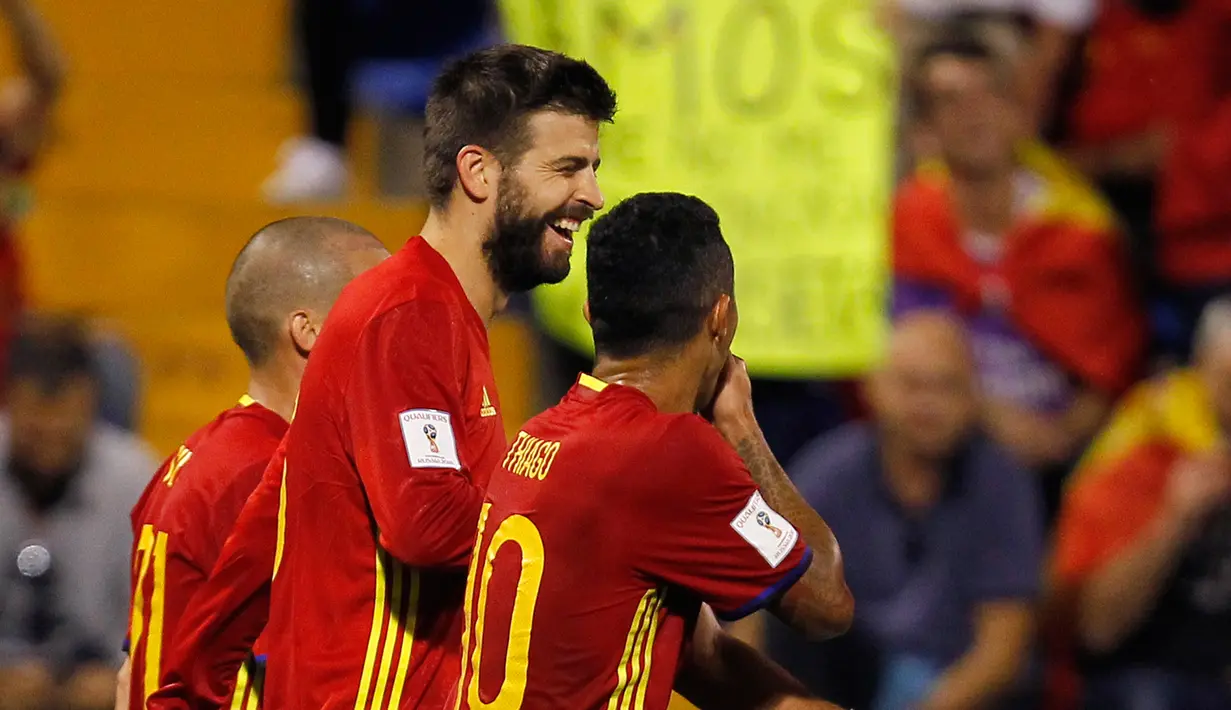 Pemain timnas Spanyol, Gerard Pique tersenyum usai Thiago Alcantara mencetak gol ke gawang Albania dalam laga Grup G Kualifikasi Piala Dunia 2018 di Stadion Jose Rico Perez, Jumat (6/10). Satu gol Thiago mewarnai kemenangan Spanyol 3-0. (AP/Alberto Saiz)