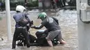 Warga mendorong sepeda motor setelah mogok akibat nekat menerobos banjir di Jalan Ahmad Yani, Jakarta, Minggu (23/2/2020). Kondisi banjir yang lama surut memaksa pengendara motor nekat menerobos, namun kebanyakan dari mereka mengalami mogok. (merdeka.com/Iqbal S. Nugroho)